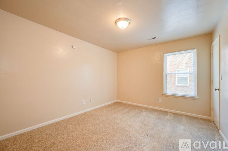 A room with a window and carpeted floor.