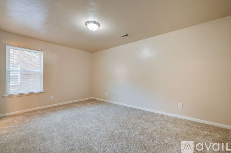 A room with a window and carpeted floor.