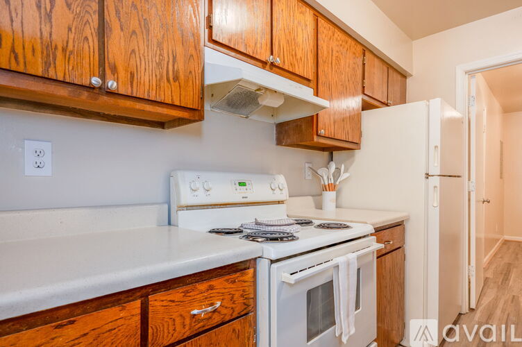 A kitchen with wooden cabinets and white appliances.