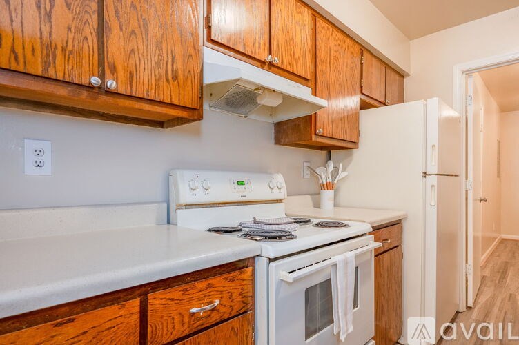 A kitchen with wooden cabinets and white appliances.