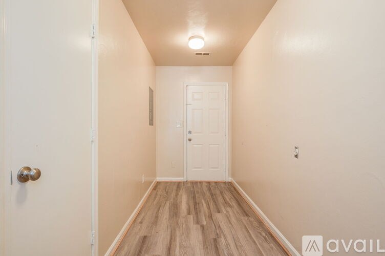 A hallway with a door at the end.