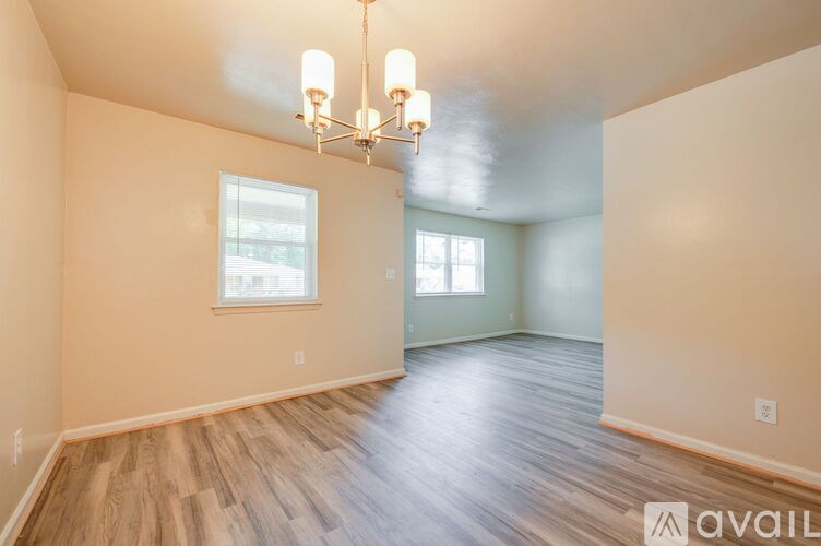A room with wooden floors and a chandelier.