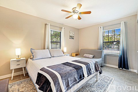 A bedroom with a large bed and a ceiling fan.