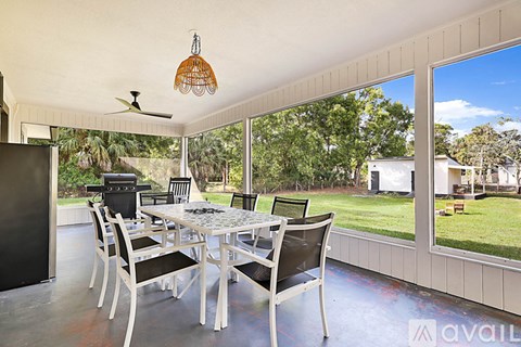 A patio with a table and chairs and a fan.