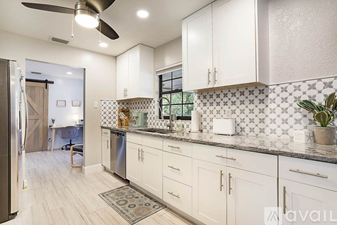 A kitchen with white cabinets and a tile backsplash.
