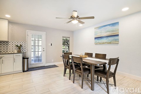 A dining room with a table and chairs.