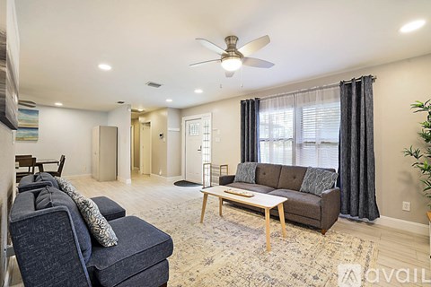 A living room with a grey couch and a blue chair.