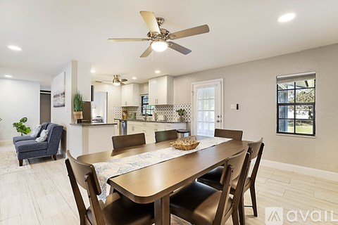 A dining room with a wooden table and chairs.