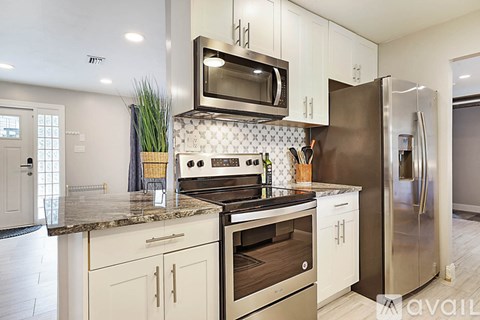 A kitchen with a stove top oven and a refrigerator.