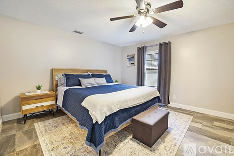 A bedroom with a bed, nightstand, and window.