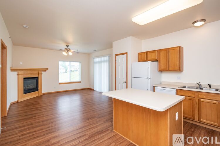 A kitchen with wooden floors and a white countertop.