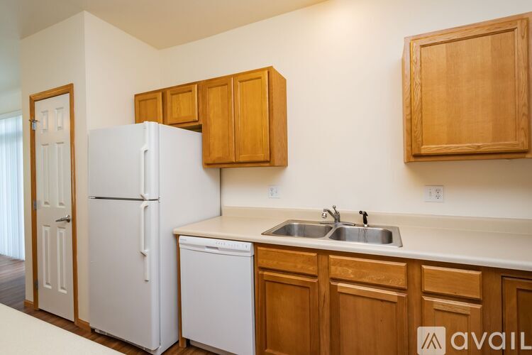 A kitchen with wooden cabinets and a white refrigerator.