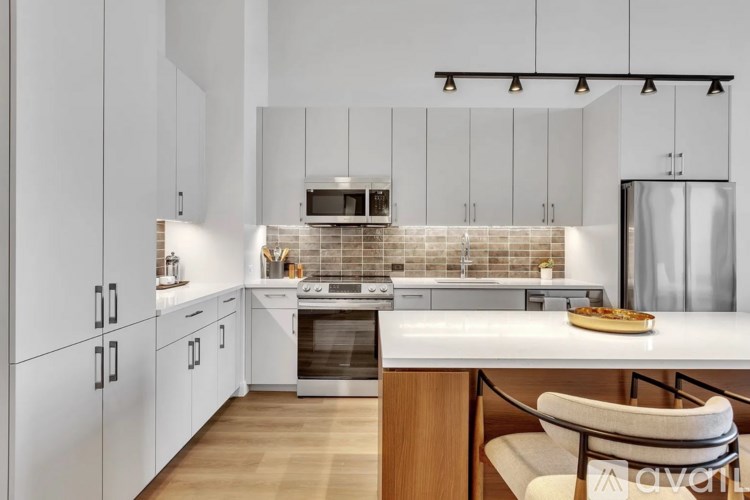 A modern kitchen with white cabinets and a wooden island.