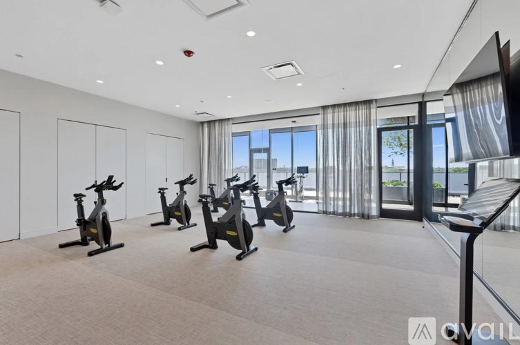 A gym with exercise bikes and a flat screen TV.