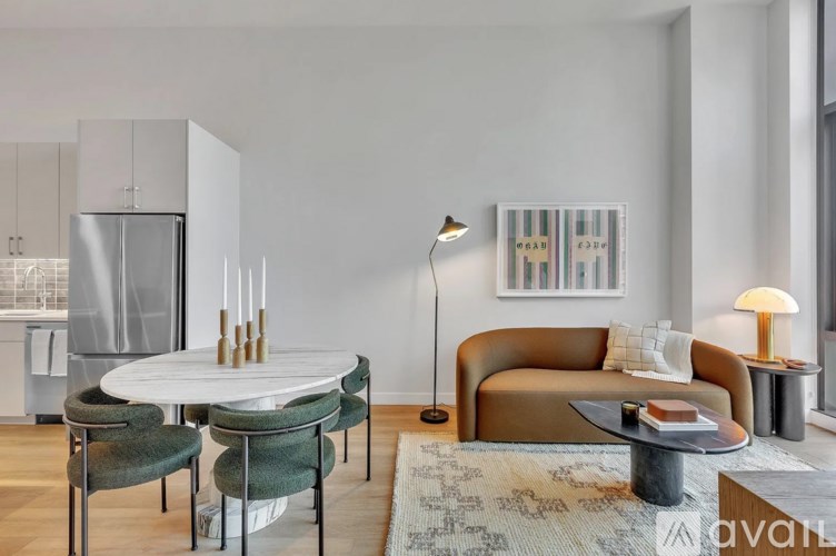 A modern living room with a round table and a brown sofa.