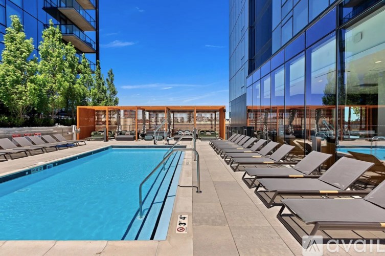 A large outdoor swimming pool with sun loungers and a wooden structure.