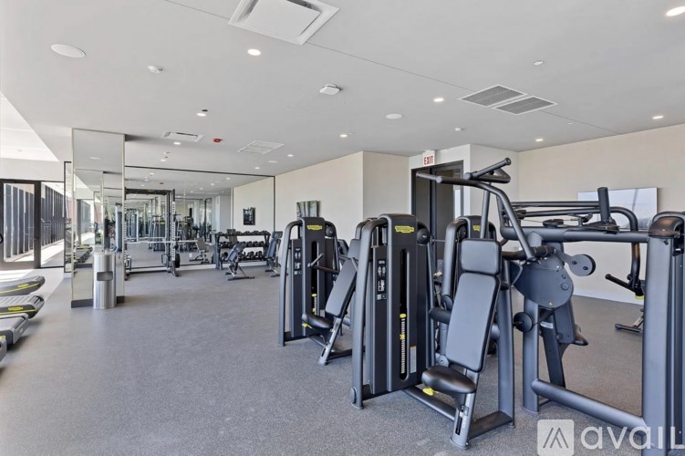 A gym with a variety of equipment including treadmills, weights, and exercise machines.