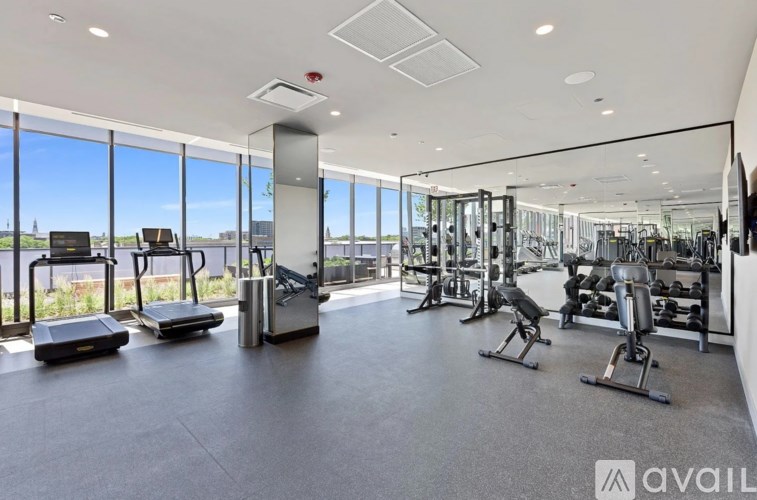 A gym with a variety of equipment including treadmills, weights, and exercise machines.