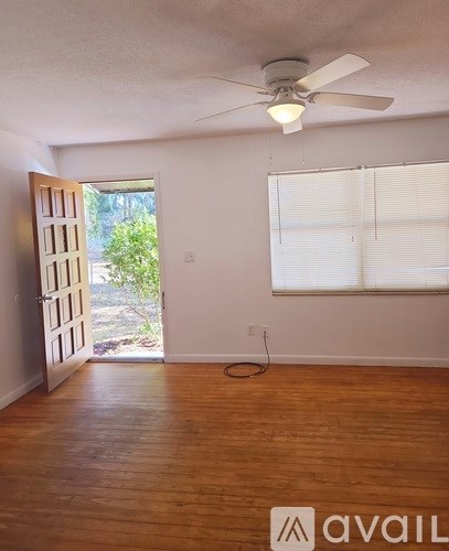 A room with a ceiling fan and a door leading outside.