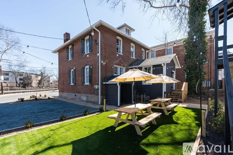 A house with a red brick exterior and a green lawn.