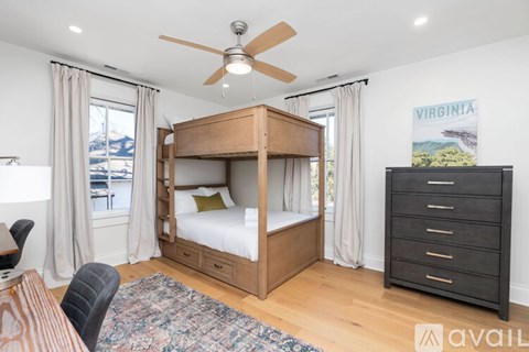 A bedroom with a bunk bed and a dresser.