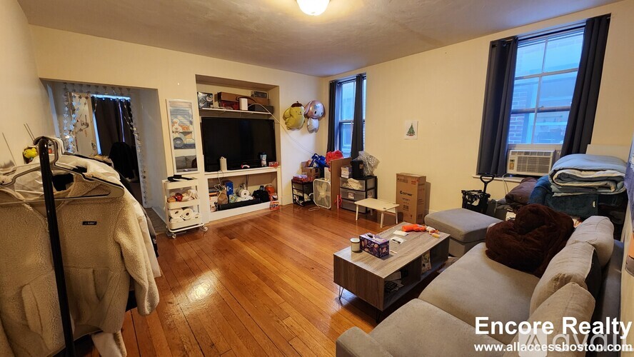 A living room with a couch, a chair, a coffee table, and a bookshelf.