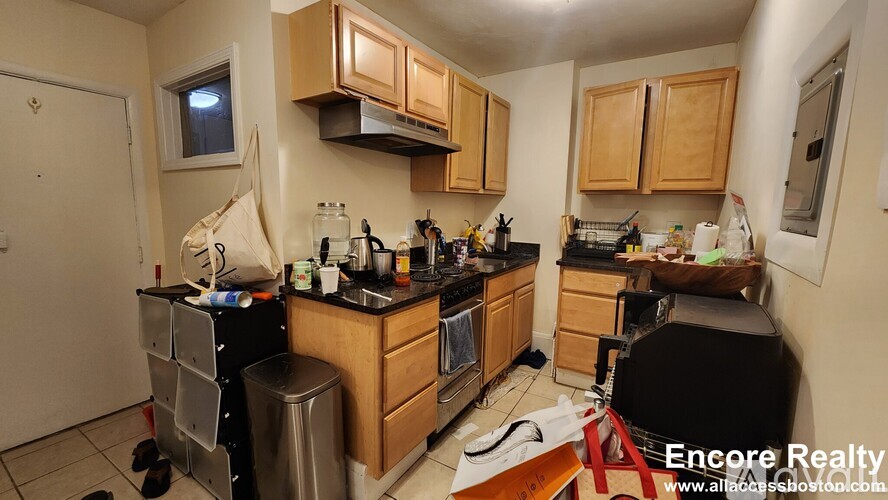 A kitchen with wooden cabinets and a black countertop.