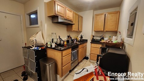 A kitchen with wooden cabinets and a black countertop.