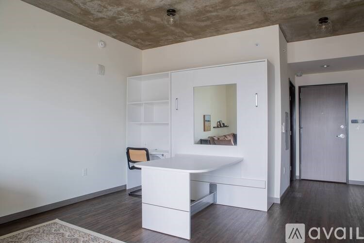 A room with a white desk and a mirror on the wall.