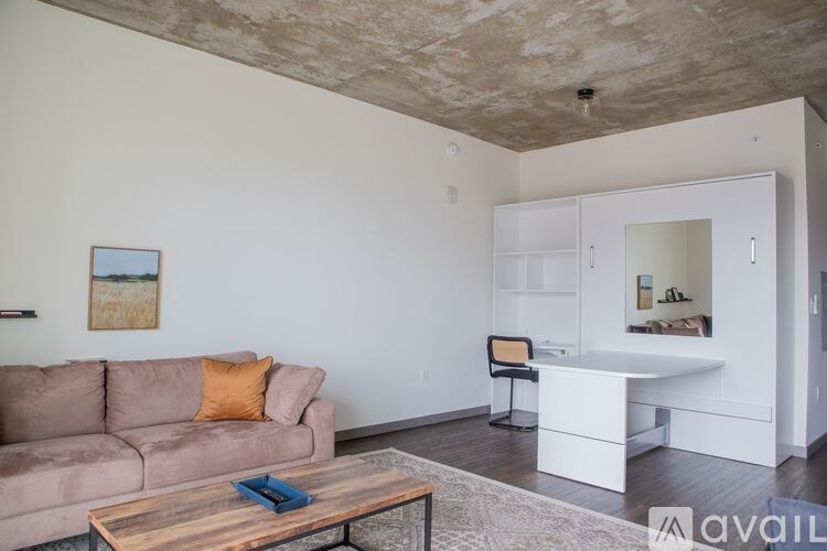 A living room with a couch, a coffee table, and a chair.