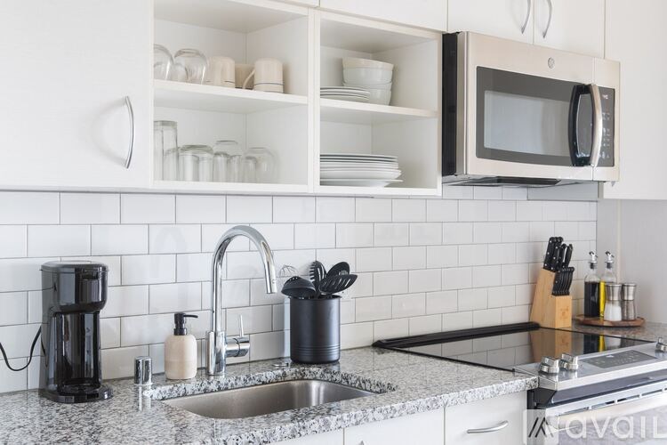 A kitchen with a sink, microwave, and coffee maker.