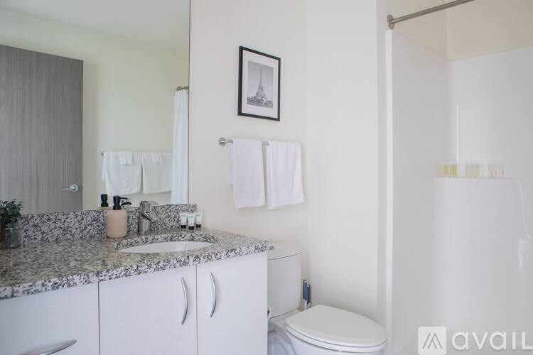 A bathroom with a granite countertop and white cabinets.