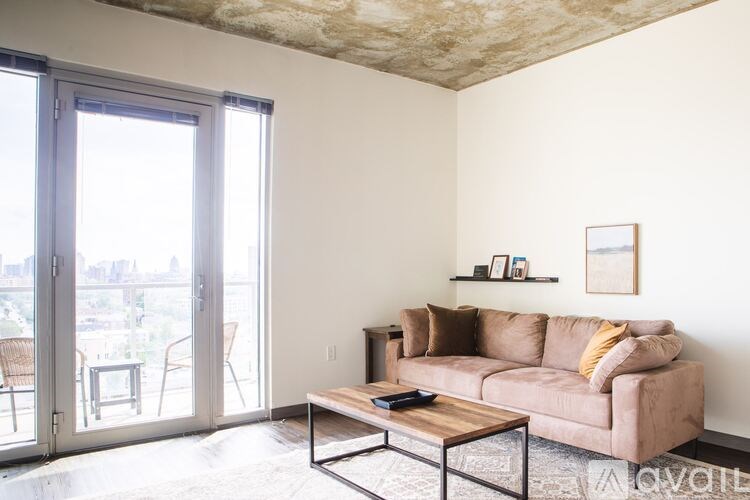 A living room with a couch, a coffee table, and a sliding glass door.