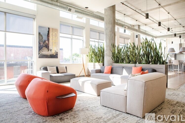 A living room with a large window, a couch, a chair, and a rug.