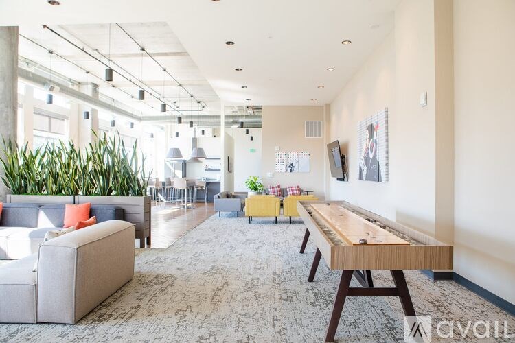 A modern living room with a grey sofa, a wooden table, and a grey rug.