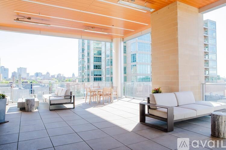 A patio with a couch, chairs, and a table with a vase of flowers on it.