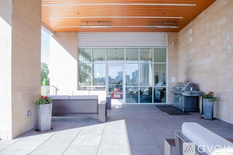 A modern outdoor seating area with a wooden ceiling and glass doors.
