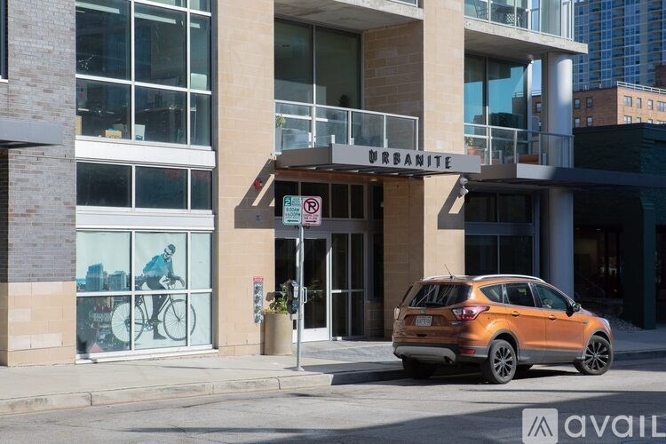 A car is parked in front of a building with a bicycle displayed in the window.