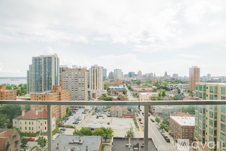 A cityscape with buildings of various heights and a parking lot in the foreground.