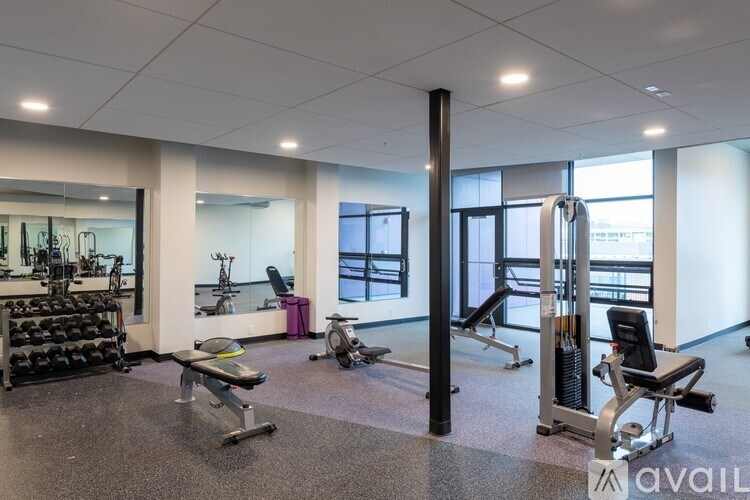 A gym with a variety of equipment including weights and machines.