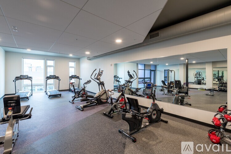 A gym with a variety of exercise equipment including treadmills, stationary bikes, and weight machines.
