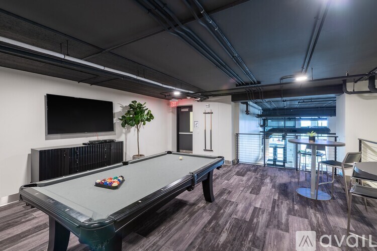 A room with a pool table and a television mounted on the wall.