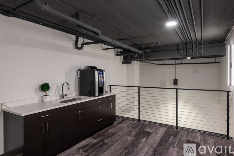 A kitchen area with a sink, a fridge, and a microwave.