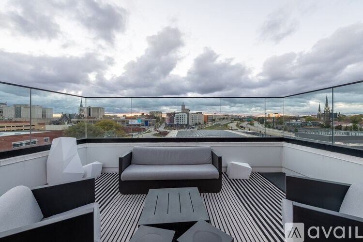 A balcony with a black and white striped floor and a table and chairs.