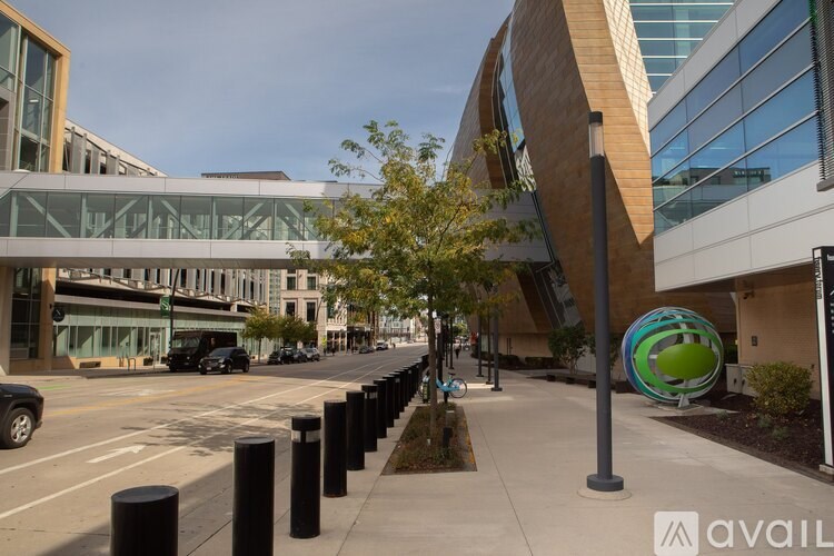 A modern building with a glass facade and a tree in front of it.