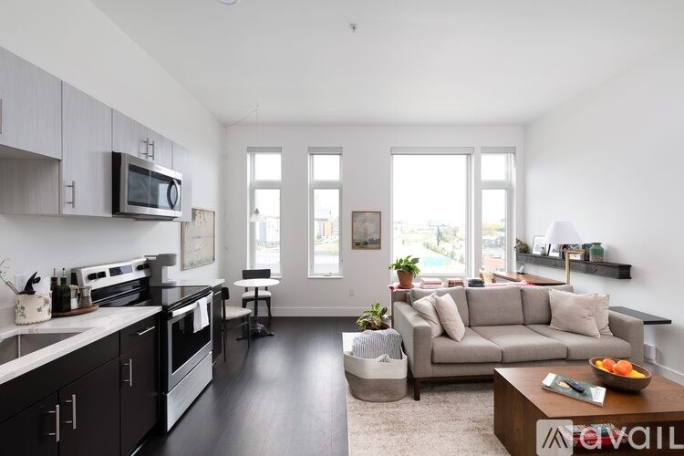 A modern kitchen with a dining area and a living room.