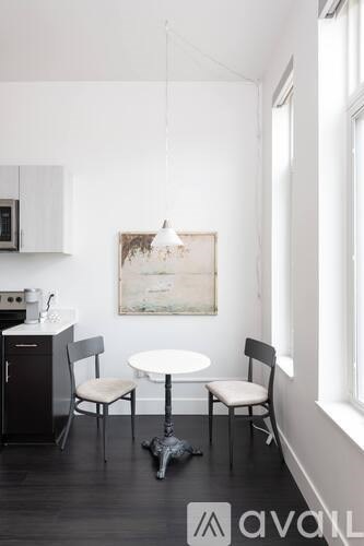 A kitchen with a table and chairs and a painting hanging on the wall.