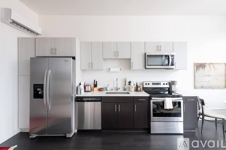 A modern kitchen with a stainless steel refrigerator and a microwave above the stove.