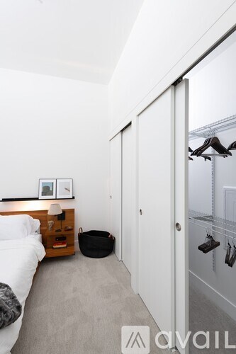 A bedroom with a bed, nightstand, and a black bag on the floor.