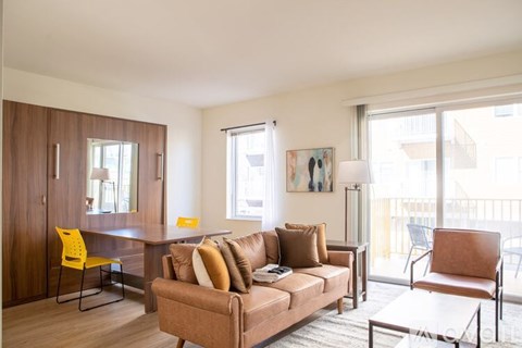 A living room with a brown couch, a yellow chair, and a coffee table.